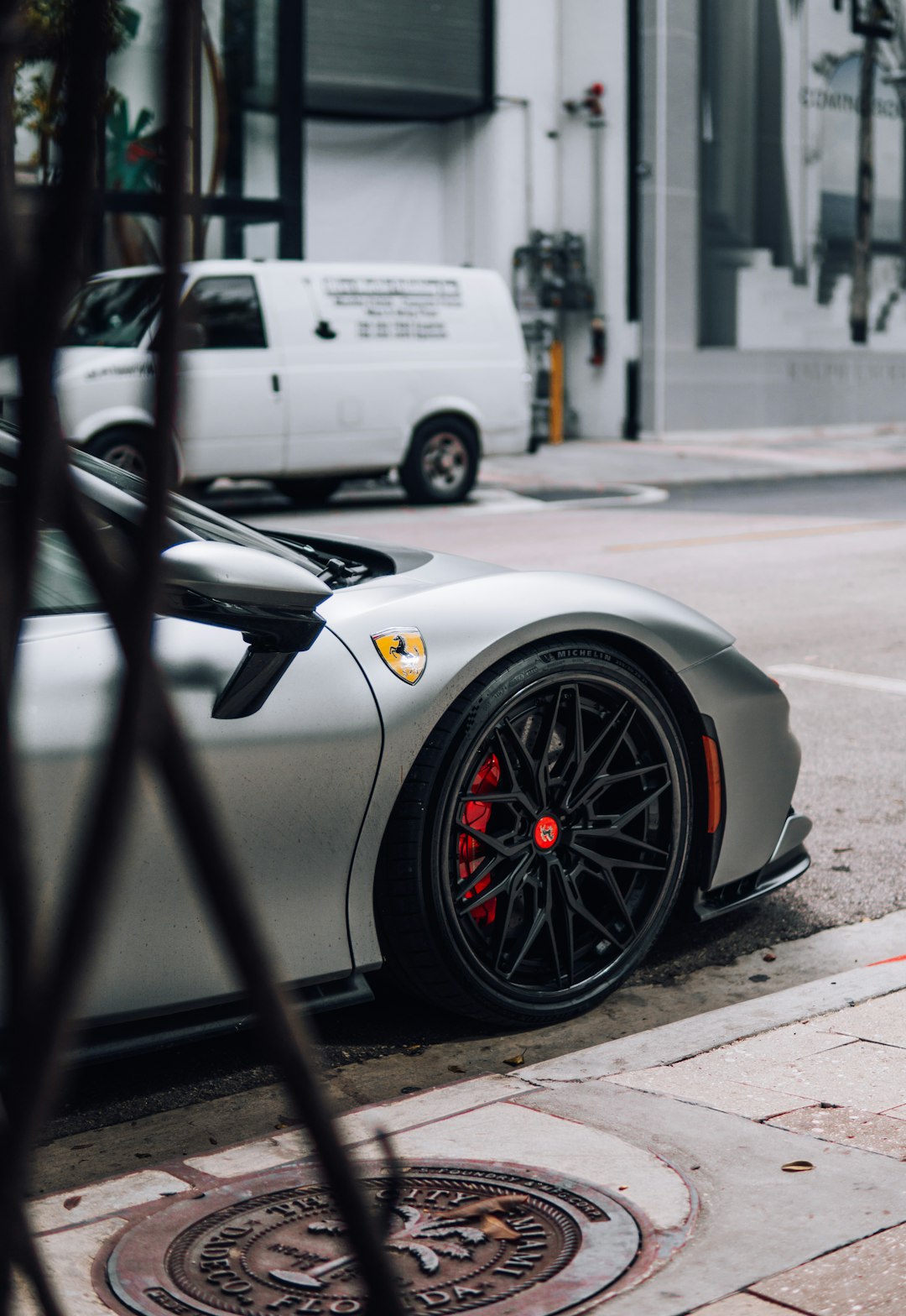 Ferrari by Moving Checklist a silver sports car parked on the side of the road