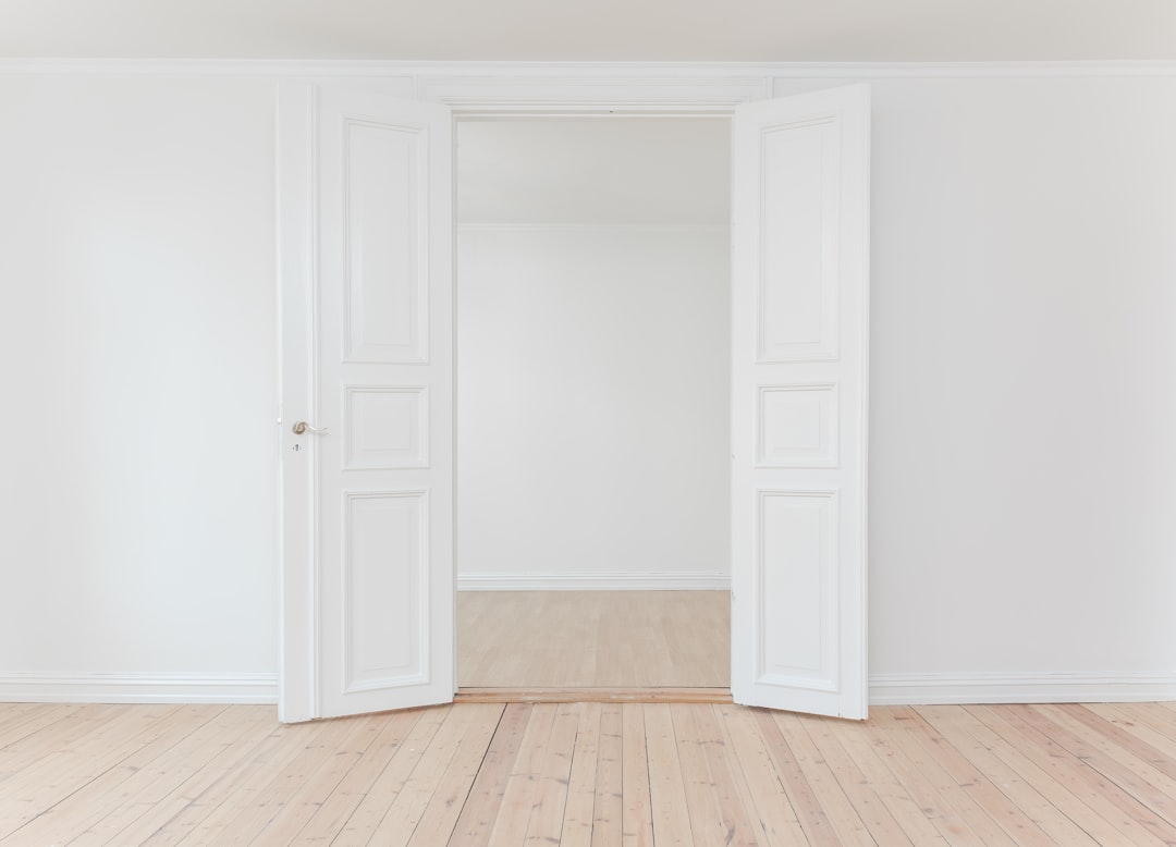 Door in a white room by Moving Checklist minimalist photography of open door